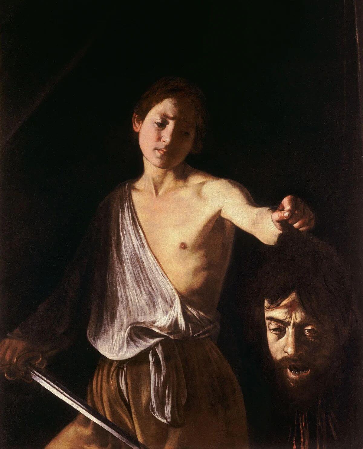 Caravaggio’s David holding Goliath’s severed head, with his sword lowered, at the Borghese Gallery.
