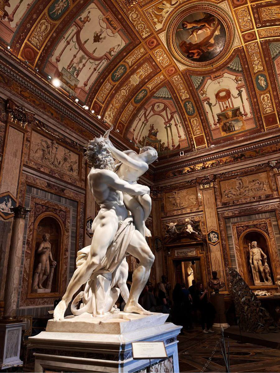Bernini's Rape of Proserpina marble sculpture in a gilded, frescoed room of the Galleria Borghese, Rome