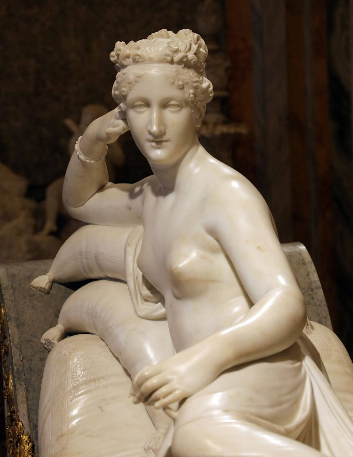 Detail of Pauline Bonaparte’s face, raised right hand, and cushions in Canova’s Venus Victrix.